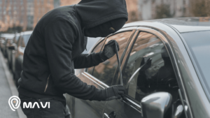 Delincuente intentando robar un auto estacionado forzando la puerta, representando el aumento de autos robados en Chile.