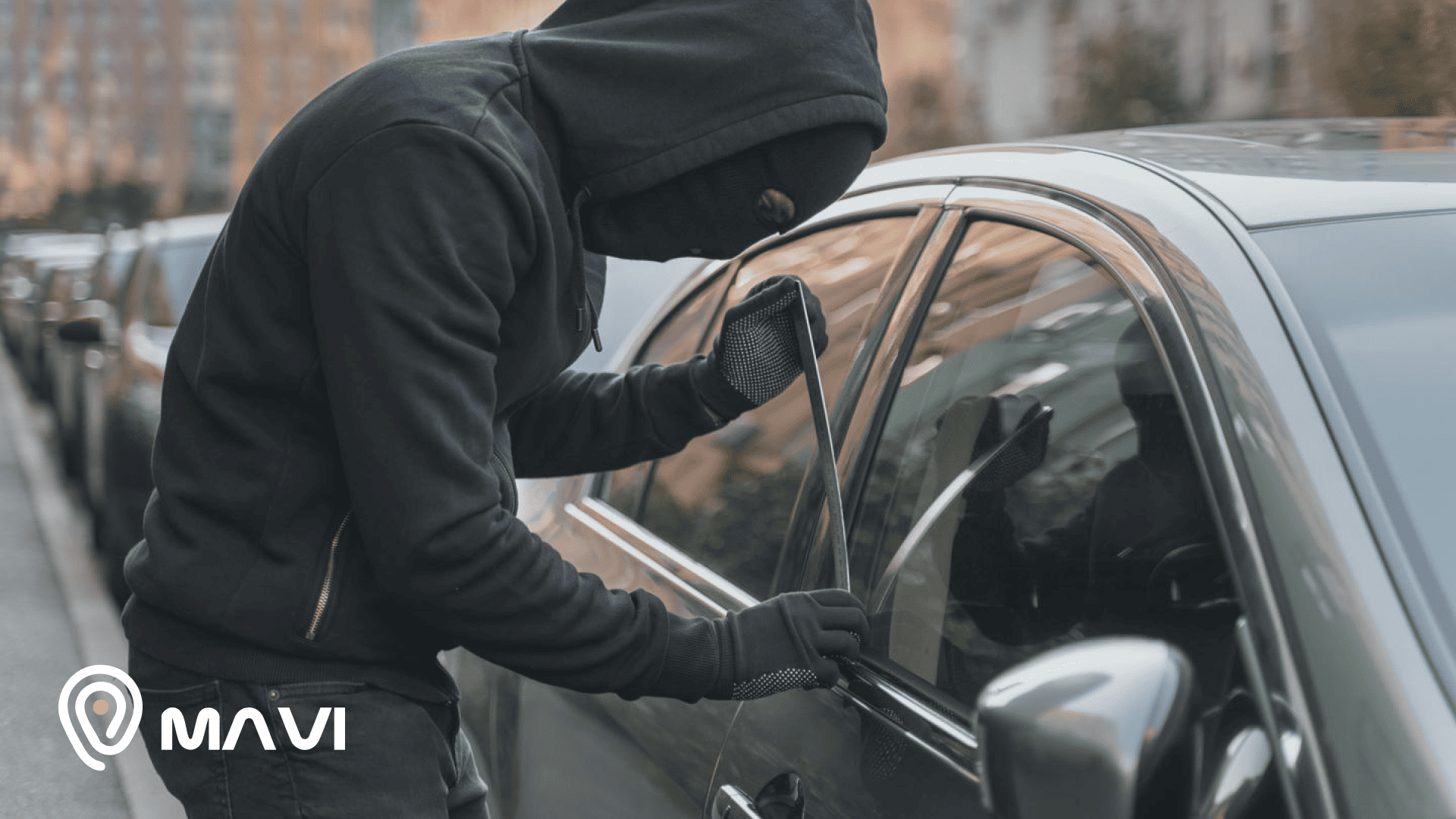 Delincuente intentando robar un auto estacionado forzando la puerta, representando el aumento de autos robados en Chile.