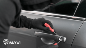 Persona intentando forzar la cerradura de un auto con herramientas, imagen que representa el robo de autos y la importancia de la seguridad vehicular.