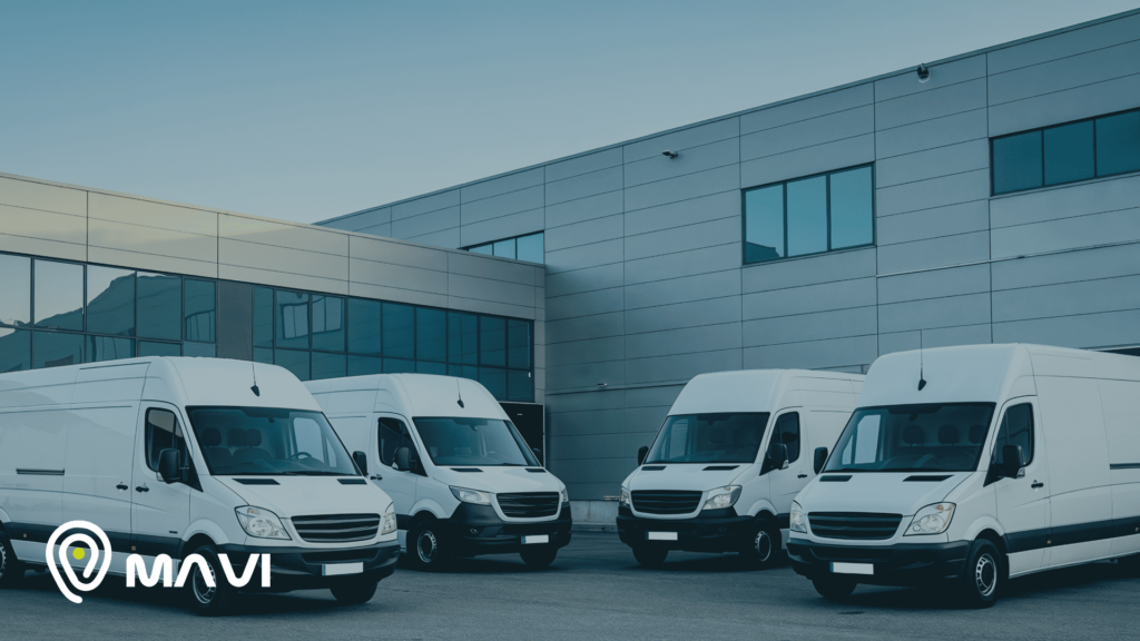 Flota de vehículos comerciales estacionados frente a edificio empresarial, representando control de flotas y seguridad vehicular con monitoreo GPS.