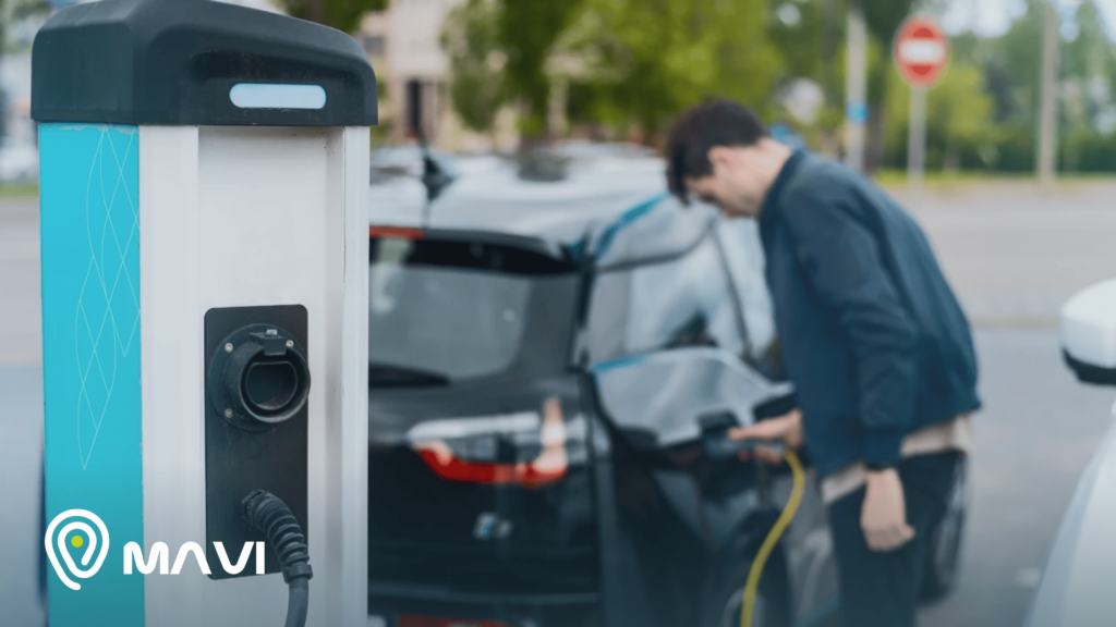Persona cargando un vehículo eléctrico en una estación, reflejando el crecimiento de autos electricos en chile