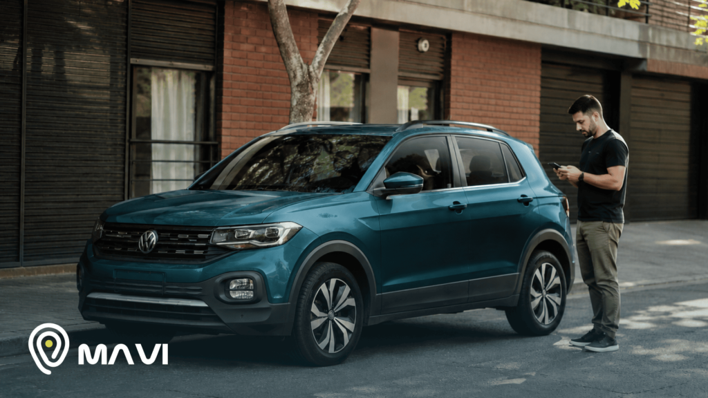 Volkswagen SUV estacionado en una calle urbana mientras un hombre revisa su celular junto al vehículo. La escena transmite control, monitoreo y seguridad vehicular con tecnología GPS.