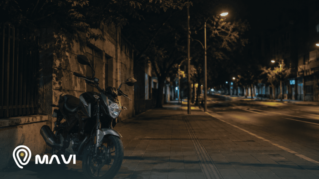 Motocicleta estacionada durante la noche en una calle urbana con poca circulación. La imagen representa la importancia de la seguridad y el monitoreo de motos en espacios públicos.