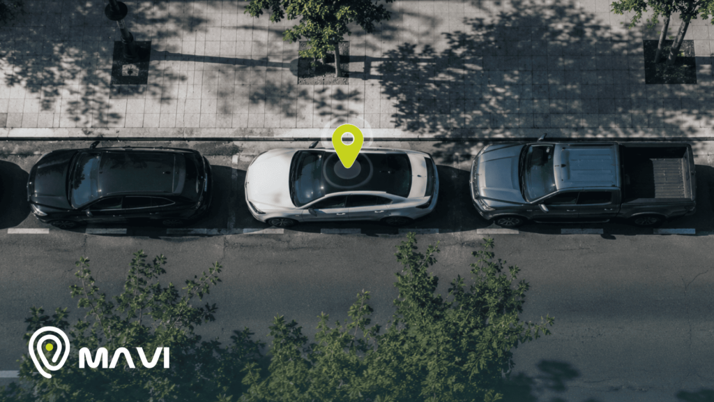 Vista aérea de vehículos estacionados en una calle, con un ícono de ubicación sobre un automóvil blanco que representa un GPS para autos en Chile y el monitoreo en tiempo real.