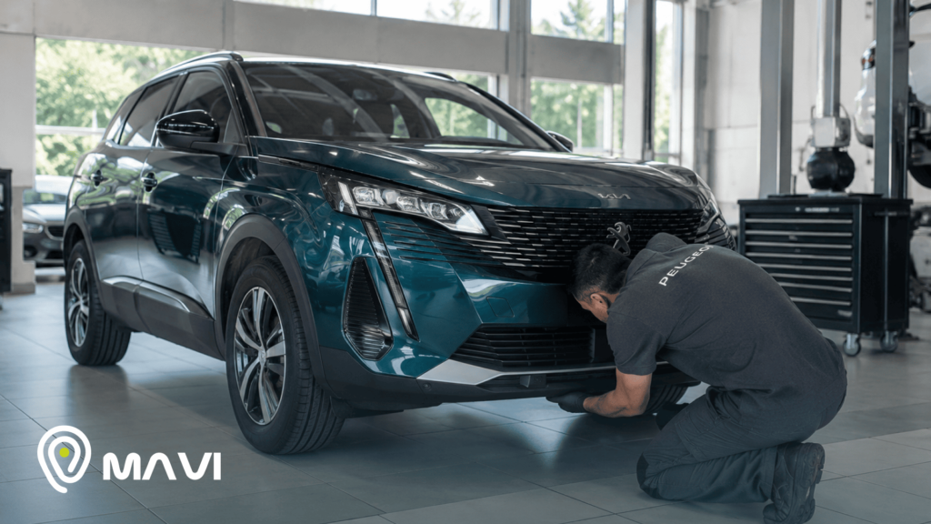 Técnico realizando la instalación de un dispositivo de seguridad en un SUV dentro de un taller automotriz. La imagen representa la implementación de una alerta de seguridad para proteger el vehículo.